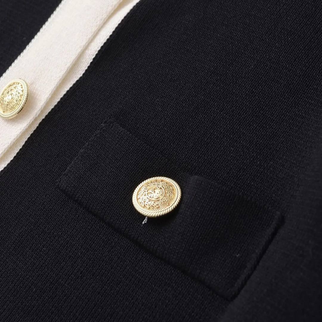 Elegant kort kofta med kontrastkant och guldfärgade knappar