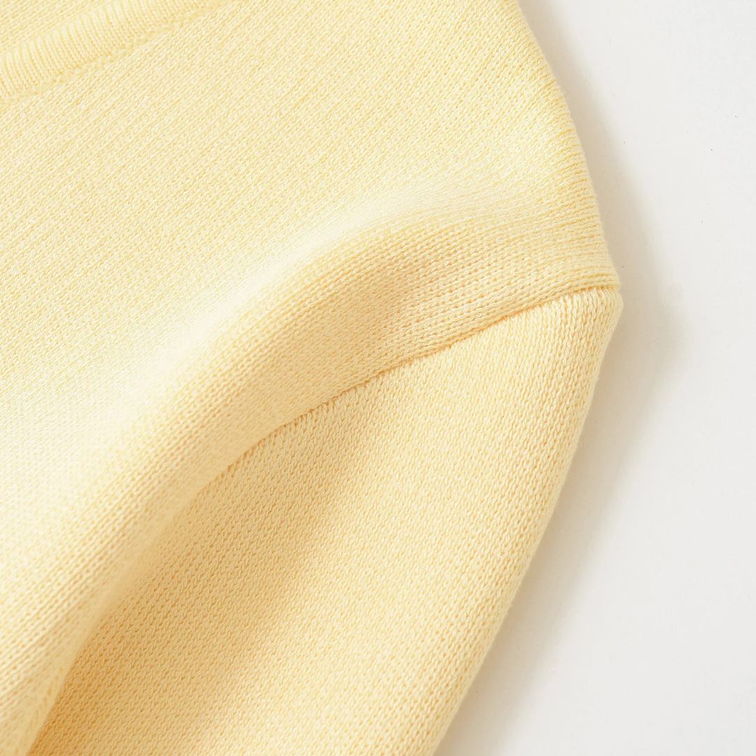 Pastellfärgad stickad kofta med V-ringning och guldfärgad knapp