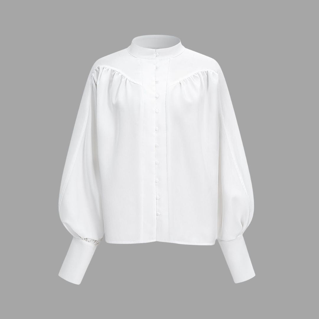 Vit blus med ståkrage täckta knappar och vida puffärmar