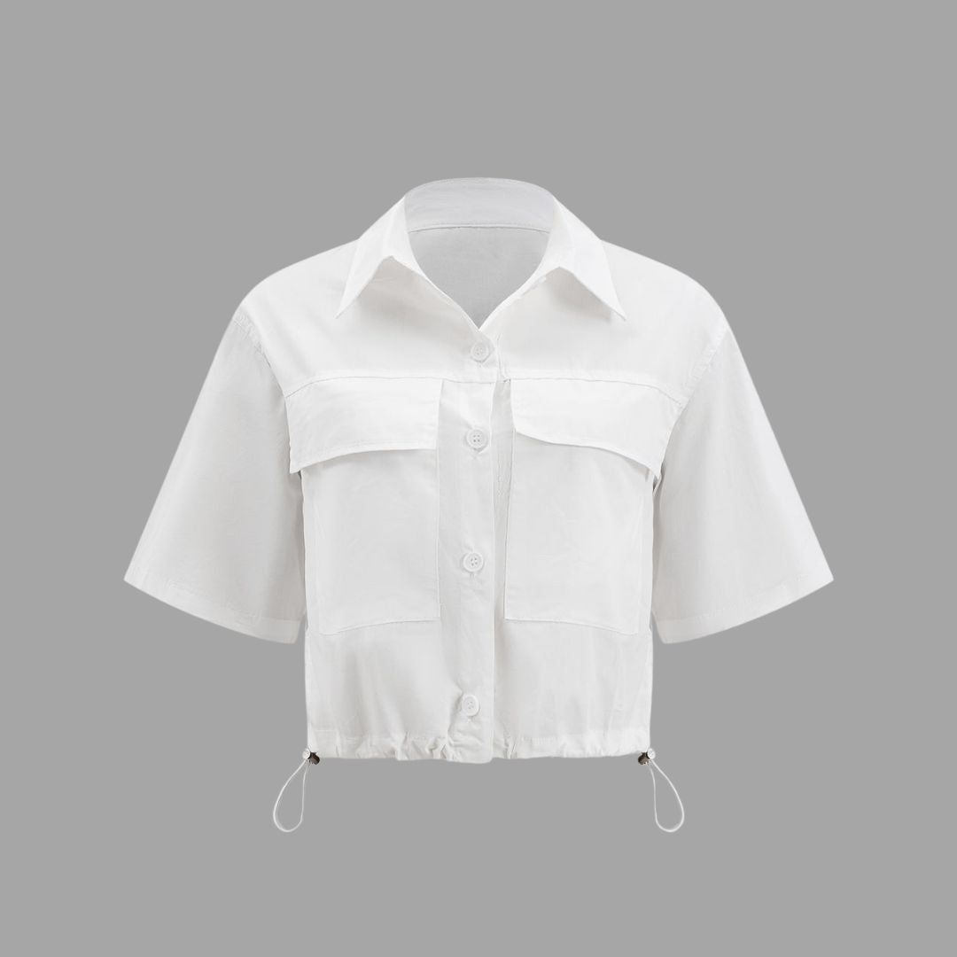 Vit kort skjortblus med stora fickor och dragsko i fållen