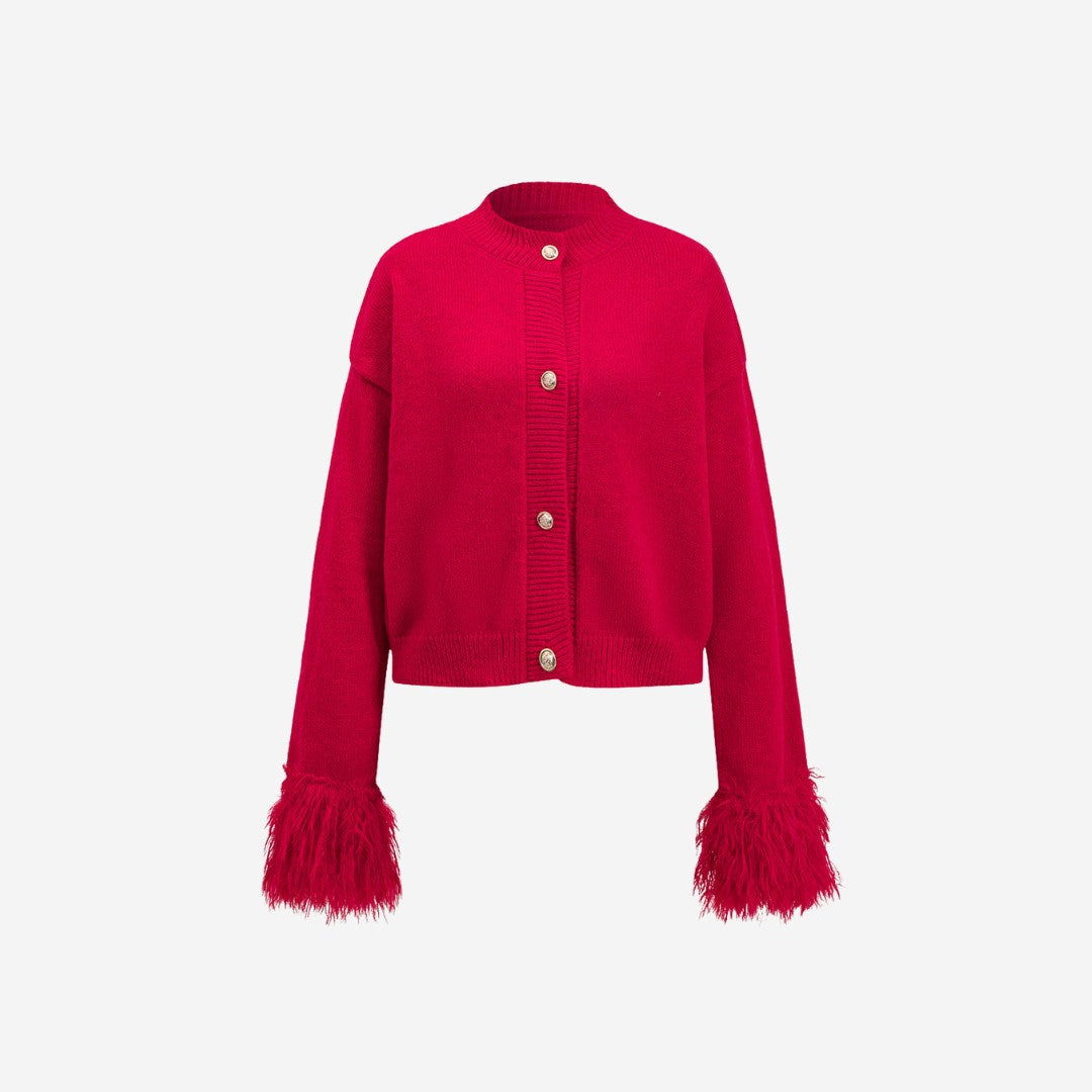Röd stickad kofta med knappslå och långa ärmar med fuskpälsdetalj