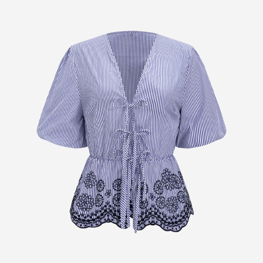 Blårandig topp med knytning framtill och broderade detaljer i fållen