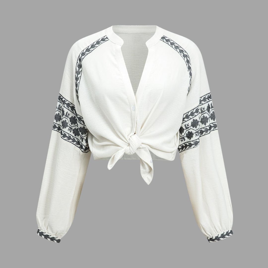 Vit blus med broderade ärmar och knytbar nederkant
