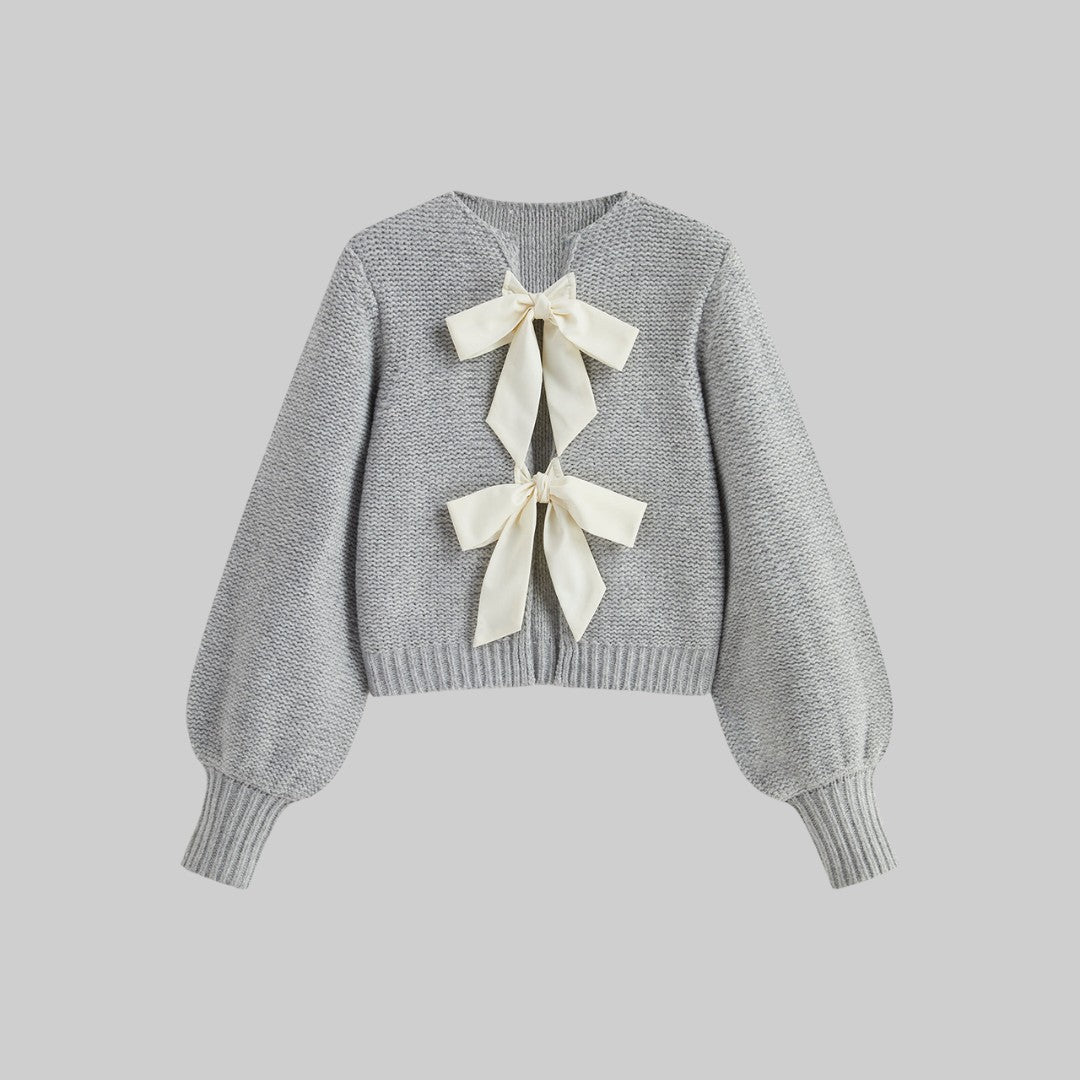 Stickad kofta med satinrosetter och ballongärmar