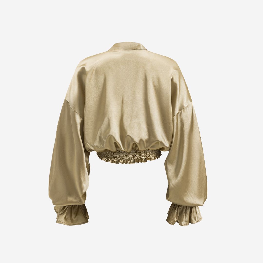 Voluminös satinblus med romantiska volangdetaljer, knytband framtill och smockade ärmslut för en sofistikerad touch
