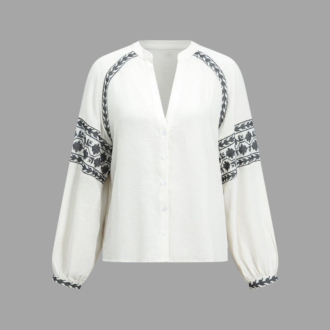 Vit blus med broderade ärmar och knytbar nederkant