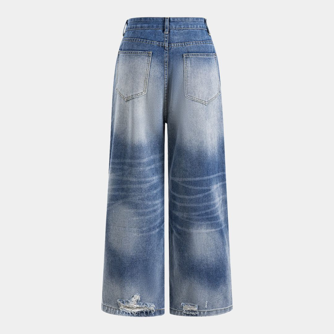 Högmidjade jeans i blekt tvätt med breda ben, markerad knappgylf och slitna detaljer baktill