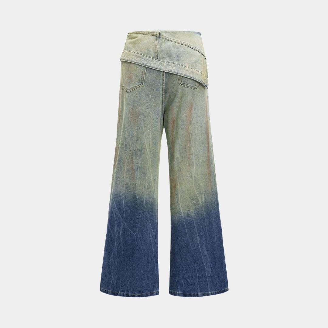 Asymmetriska denimjeans med omlottdesign, blekt färgövergång och vid passform i kraftig bomullsblandning