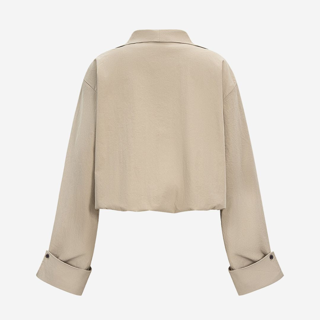 Beigefärgad kort topp med djup V-ringning och vida ärmar i stretchigt tyg