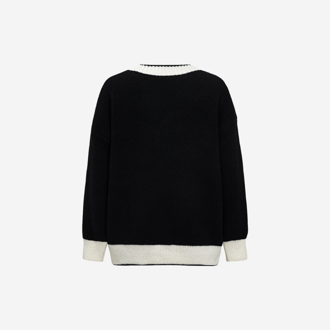 Svart stickad kofta med kontrastkant, guldknappar och lös passform