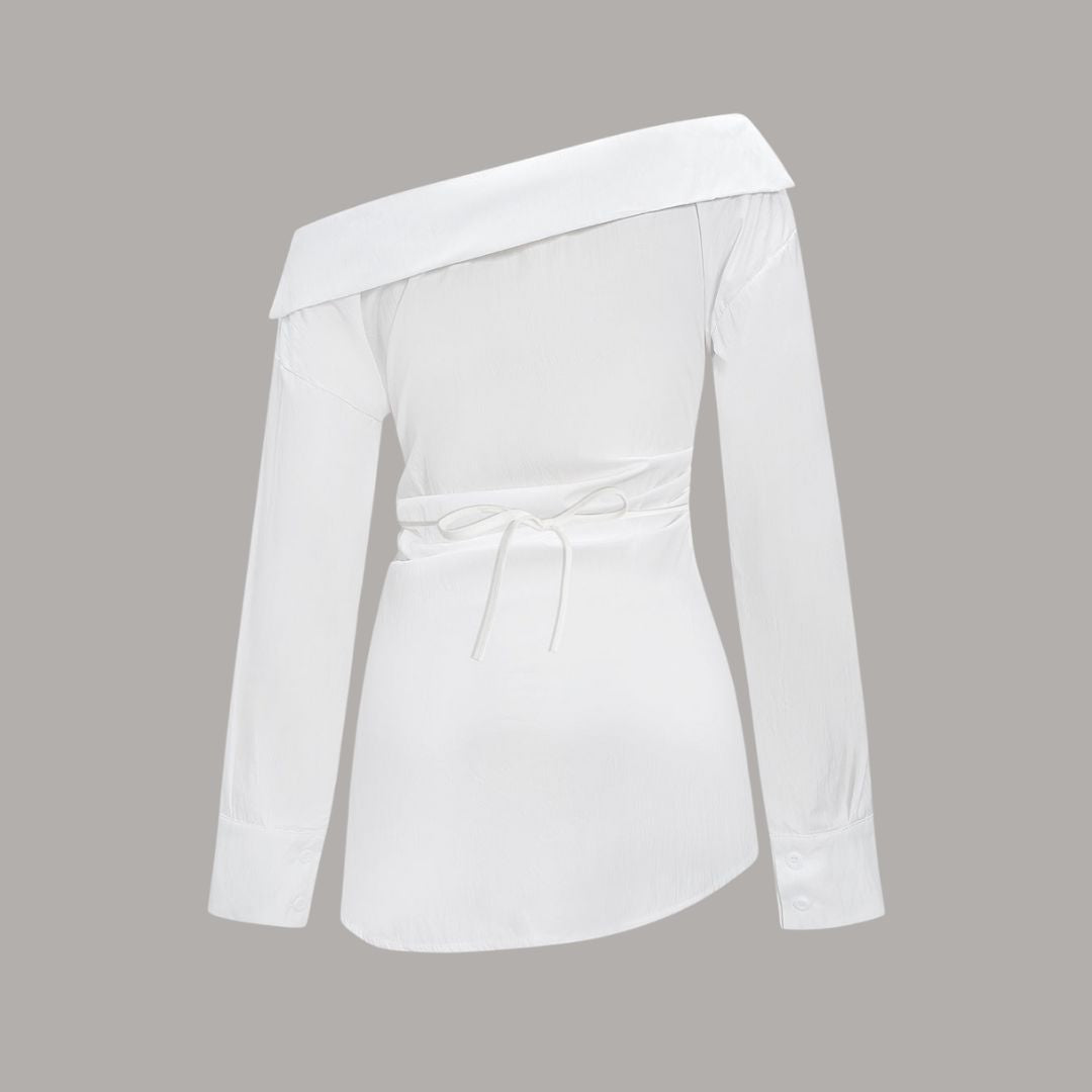 Asymmetrisk topp med bar axel och markerad midja stilren design med skulptural silhuett