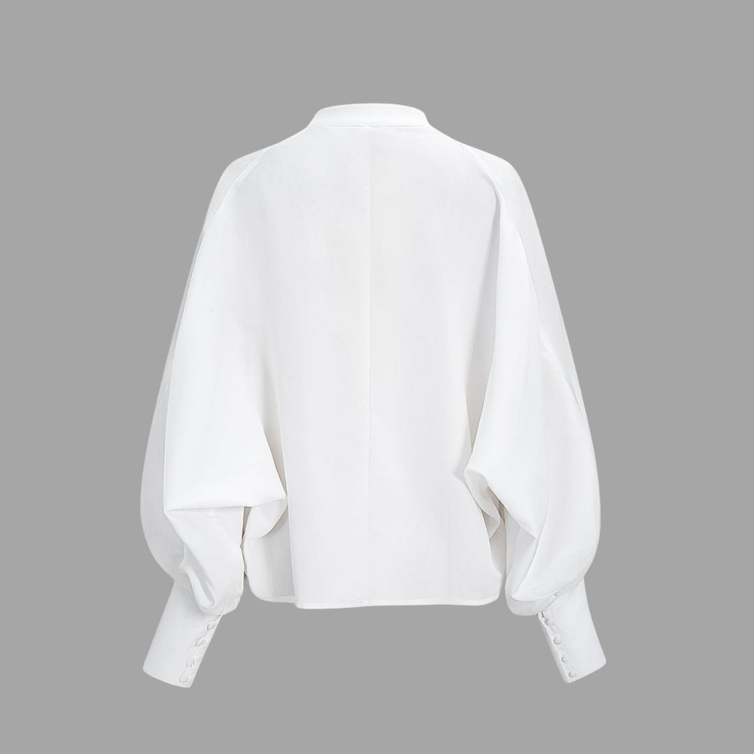 Vit blus med ståkrage täckta knappar och vida puffärmar