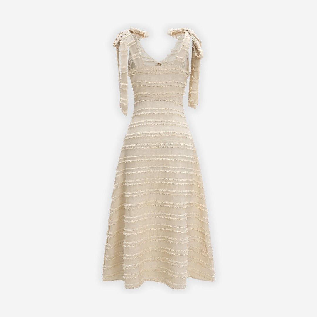 Krämvit midiklänning med knytbara axelband, strukturerad textur och A-linjeform