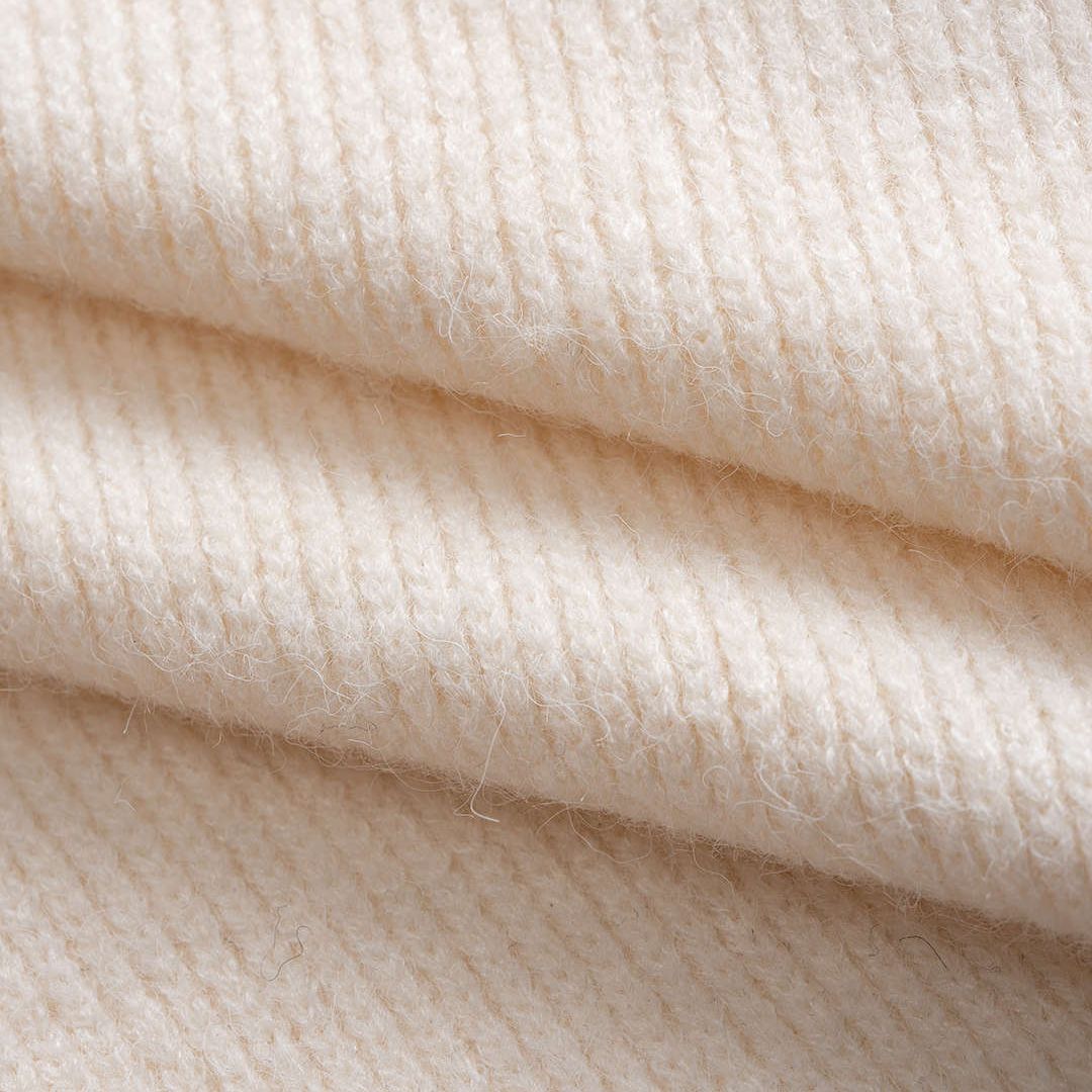 Vit stickad kofta med kontrastkant och dekorativa knappar