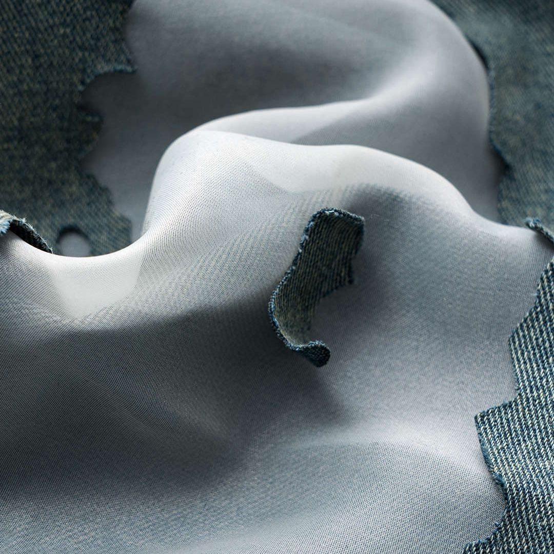 Höga ljusblå jeans med kraftiga slitningar, transparenta infällningar och bred rak passform i strukturerad denim