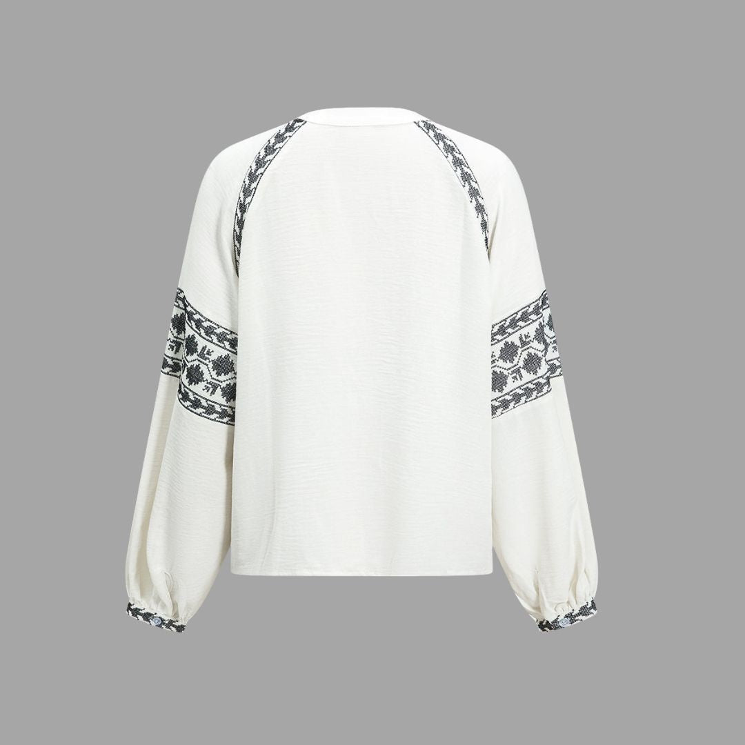 Vit blus med broderade ärmar och knytbar nederkant