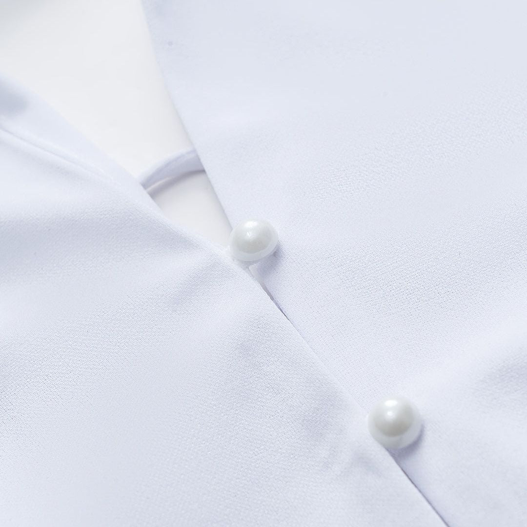 Vit långärmad topp med snörning i ryggen och pärlknappar framtill