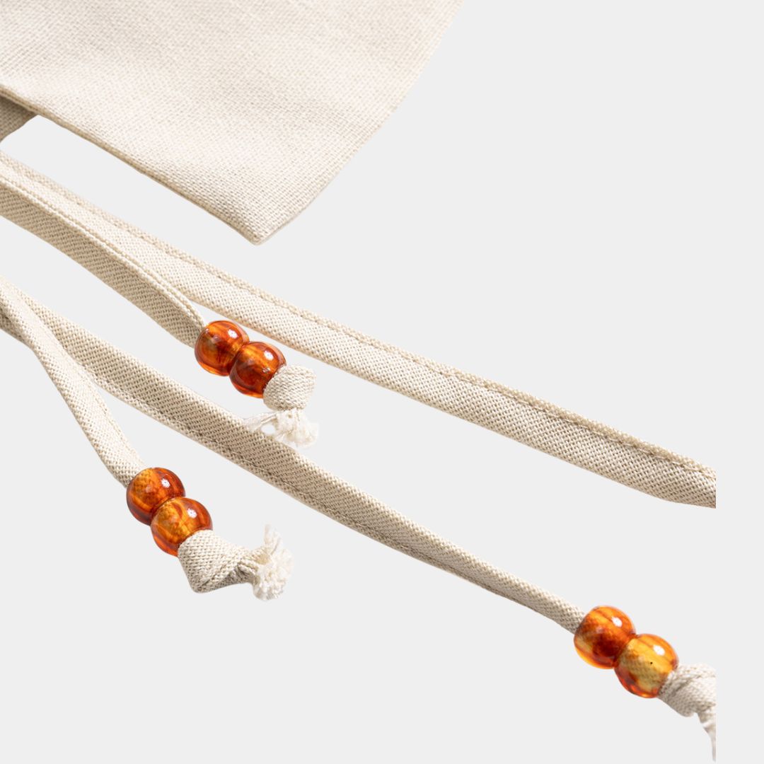 Beige ärmlös väst i vävd struktur med dekorativa snören och pärldetaljer