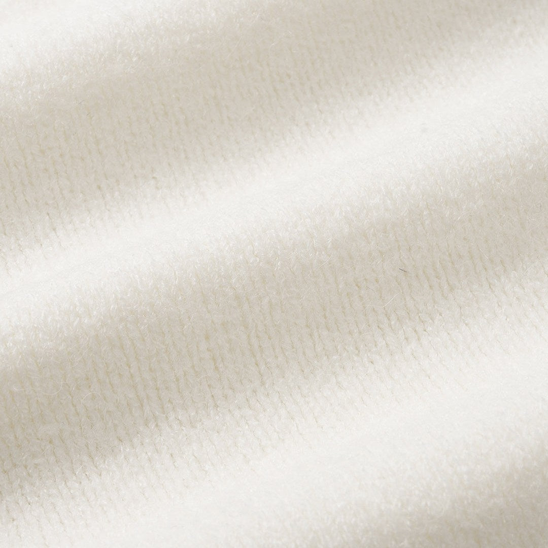 Krämvit stickad tröja med asymmetrisk knäppning, långärmad och mjuk struktur