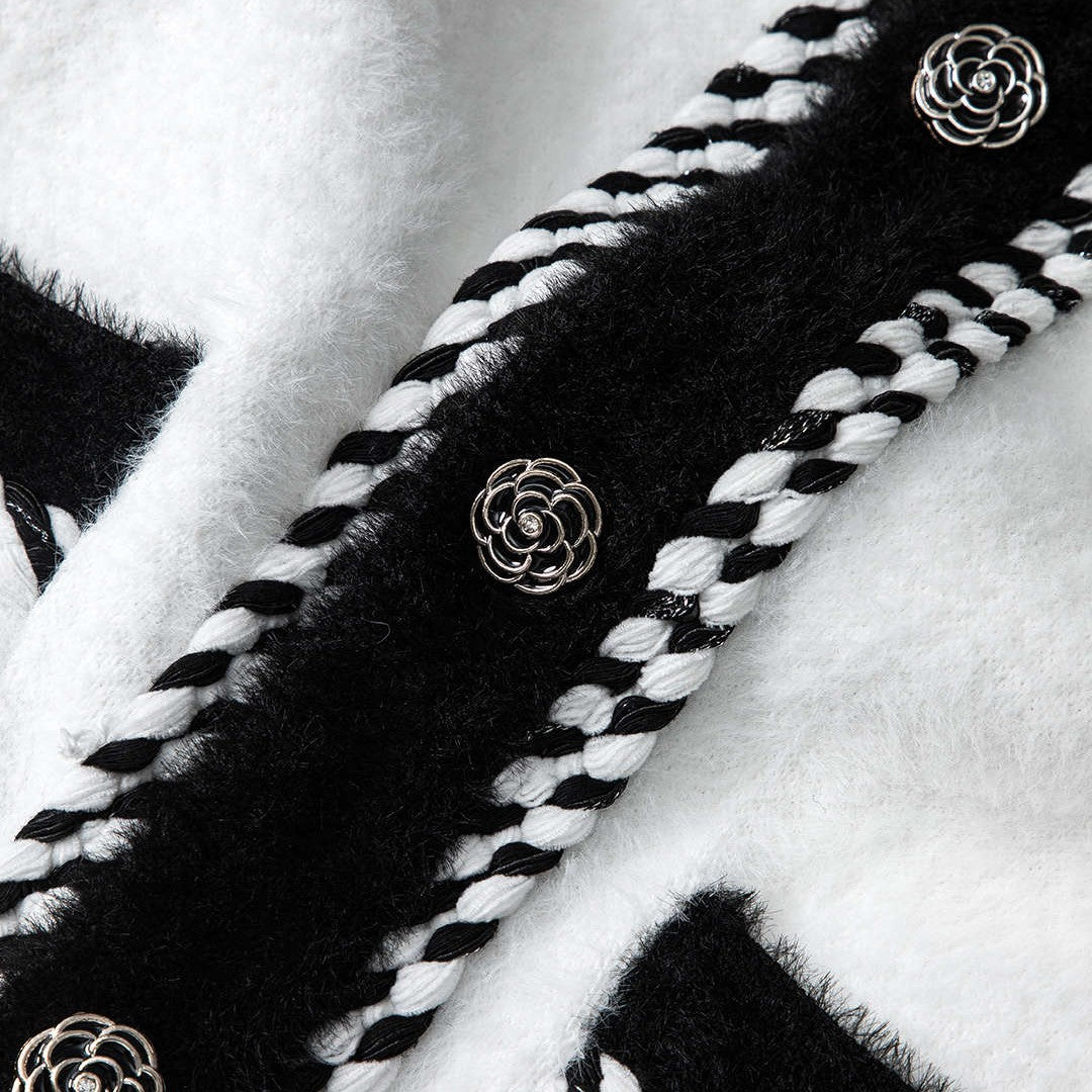 Svartvit stickad kofta med dekorativa knappar och fyrfickdesign