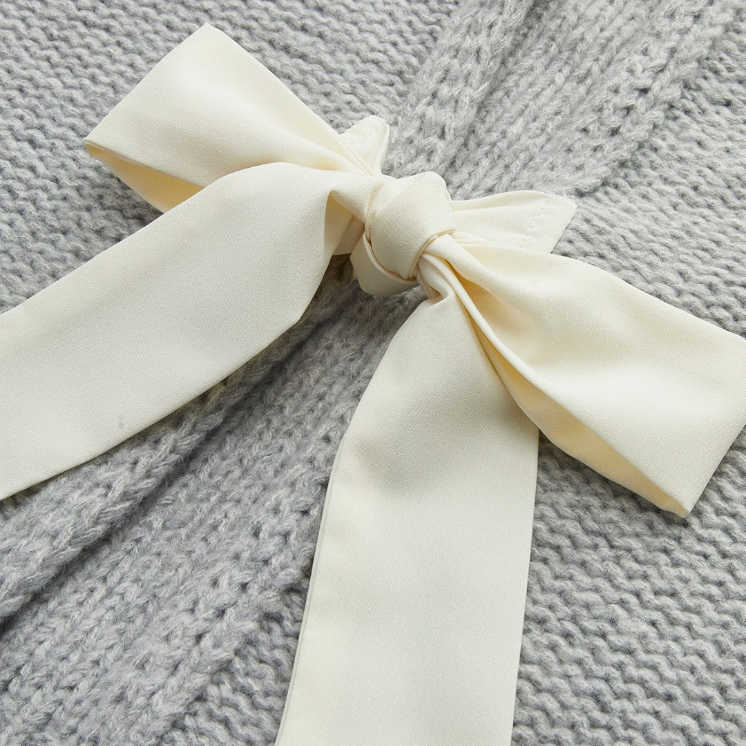 Stickad kofta med satinrosetter och ballongärmar