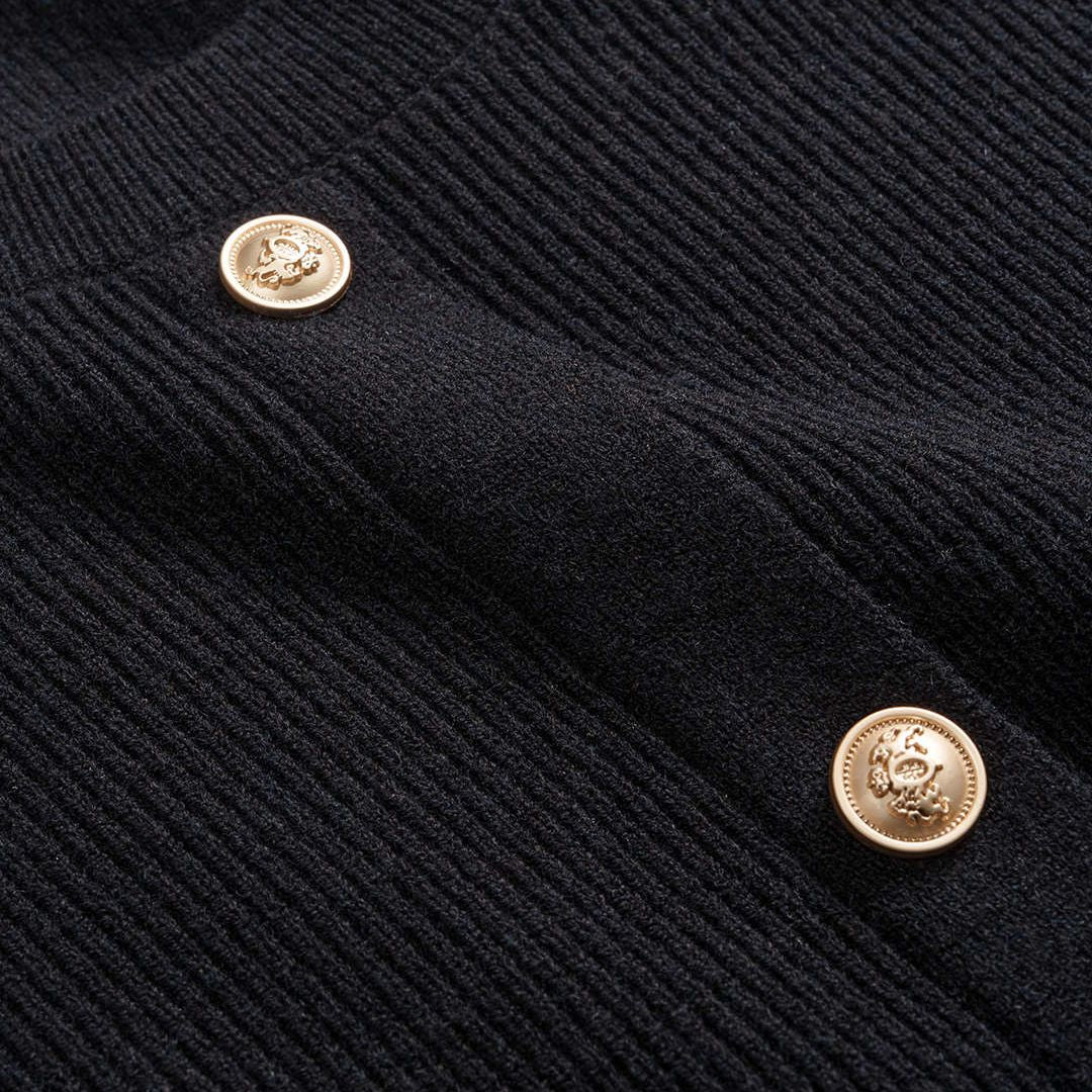 Svart figursydd stickad kofta i ribbat material med guldfärgade knappar och rund halsringning för dam