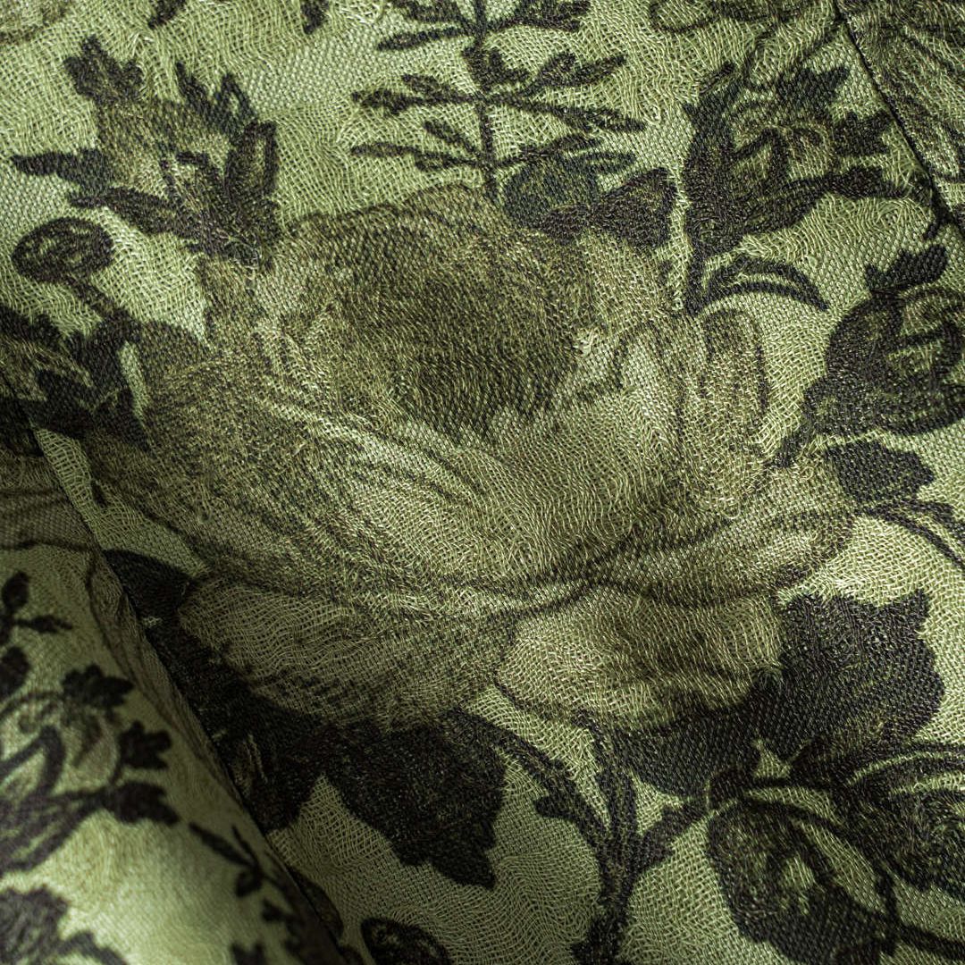 Grön ärmlös väst i olivgrön ton med blommigt jacquardmönster och asymmetrisk nederkant