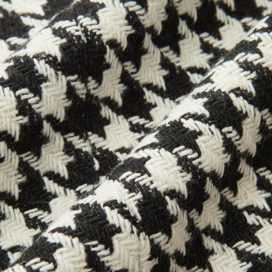 Svartvit tweedkavaj med dubbelknäppning, markerad midja och klassiskt hundtandsmönster