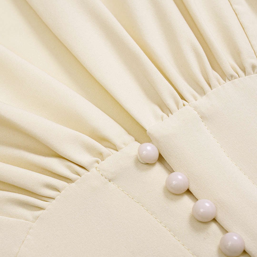 Elegant elfenbensvit topp med figurnära midjeskärning, dekorativa knappar och knytband i ryggen