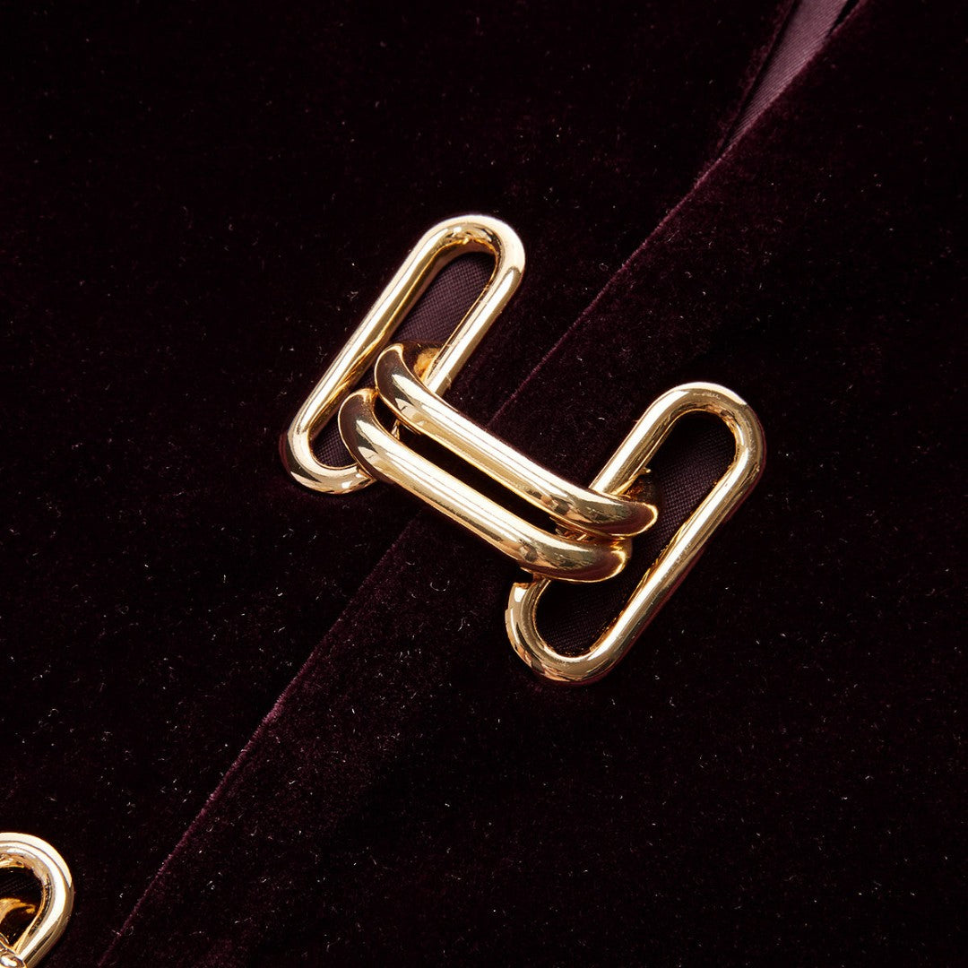 Vinröd sammetsjacka med dekorativa guldfästen och figursydd silhuett