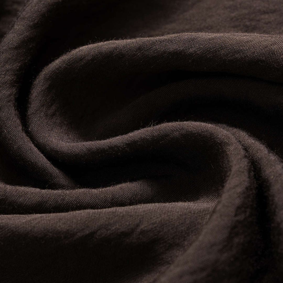 Mörkbrun asymmetrisk topp med halsbandseffekt och silverfärgade nitar