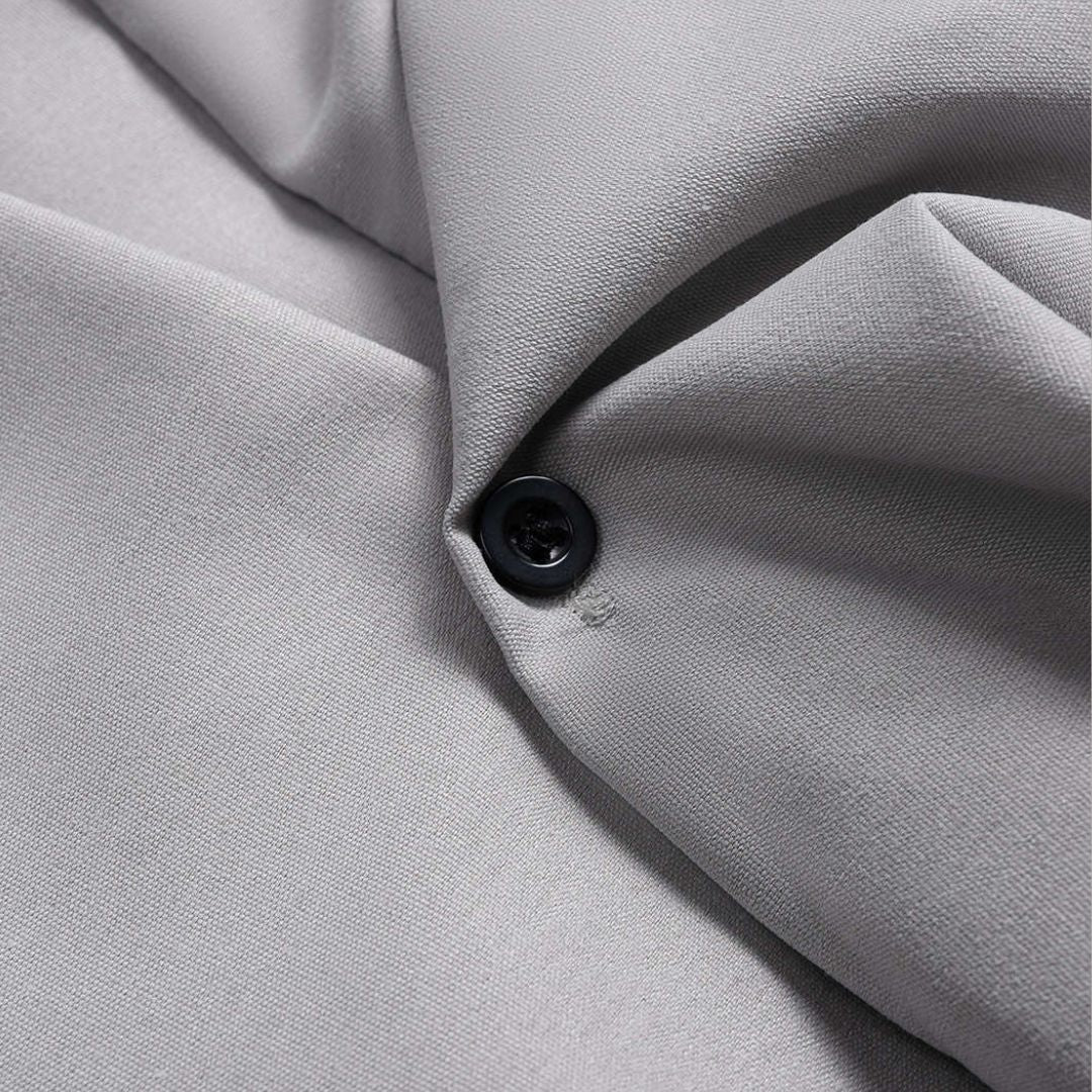 Grå figursydd skjortblus med voluminösa ballongärmar och knappar framtill