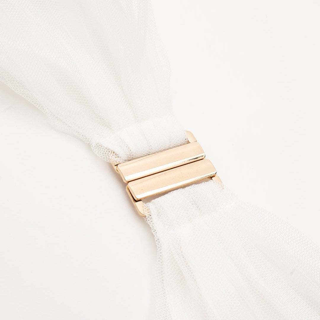 Vit tyllklänning med djup halterneck, volangmidja och plisserad maxikjol