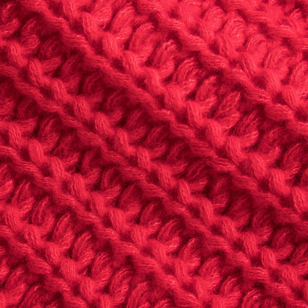 Stickad väst i grov röd maskstickning med dekorativa knappar och framfickor