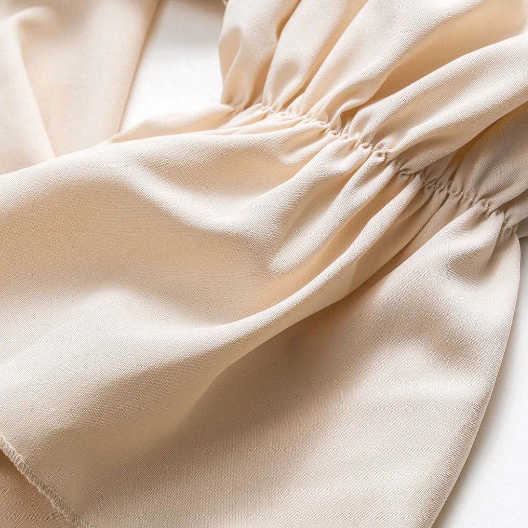 Beige blus med voluminösa volanger och rynkade ärmar