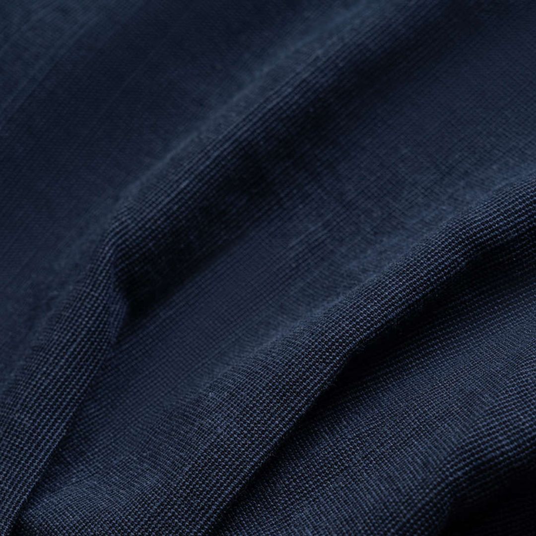 Mörkblå topp med draperade sidor och flätad halsringning