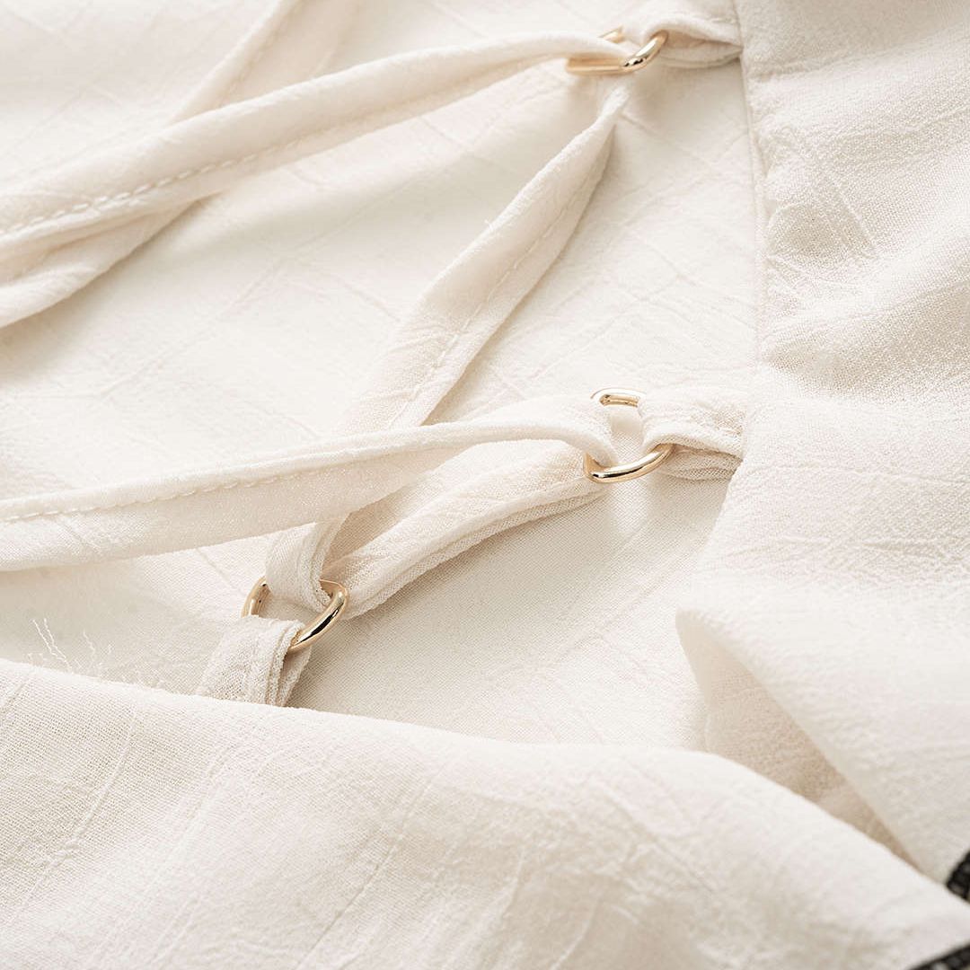 Vit chiffongblus med volanger kontrastkant och snörning vid halsringningen