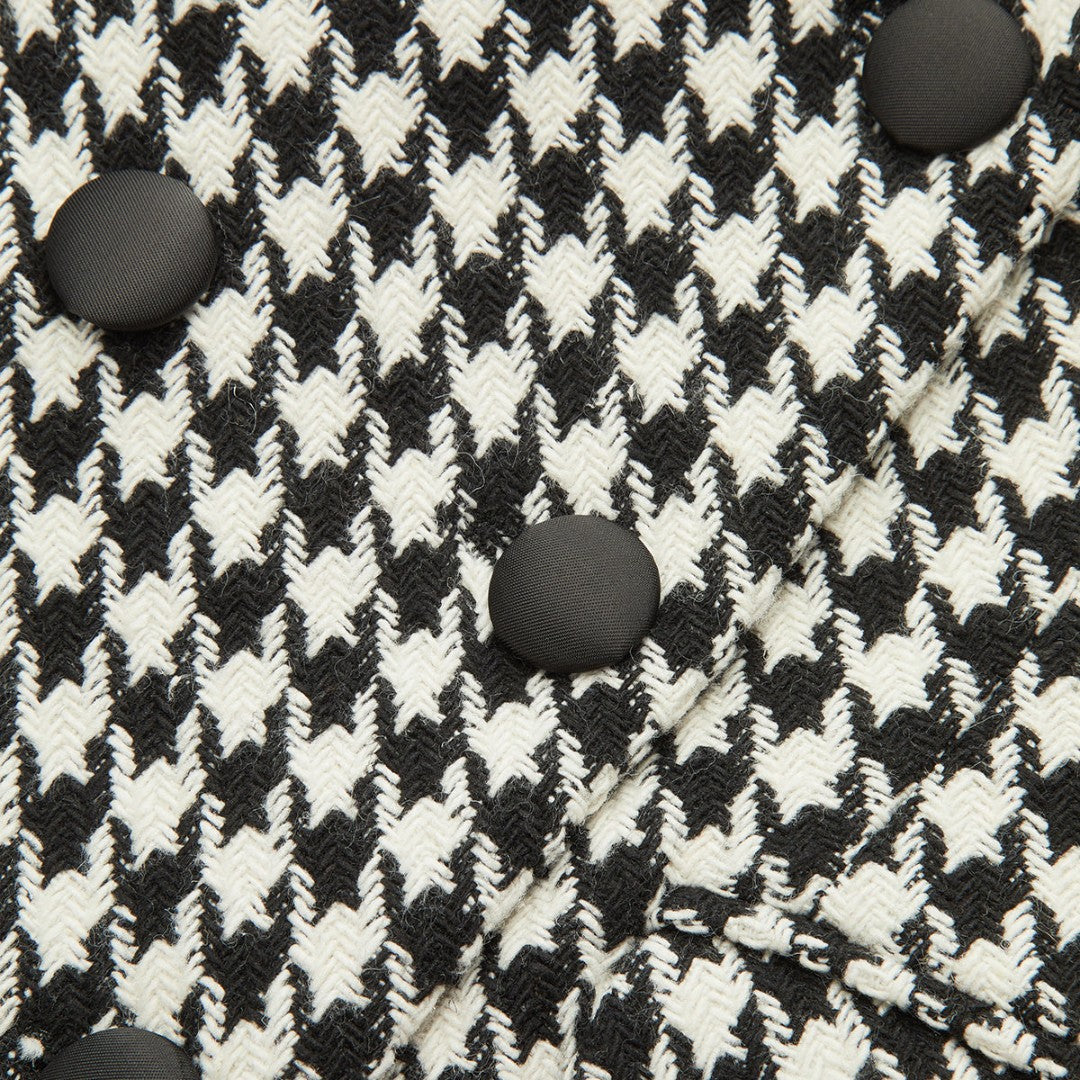 Svartvit tweedkavaj med dubbelknäppning, markerad midja och klassiskt hundtandsmönster
