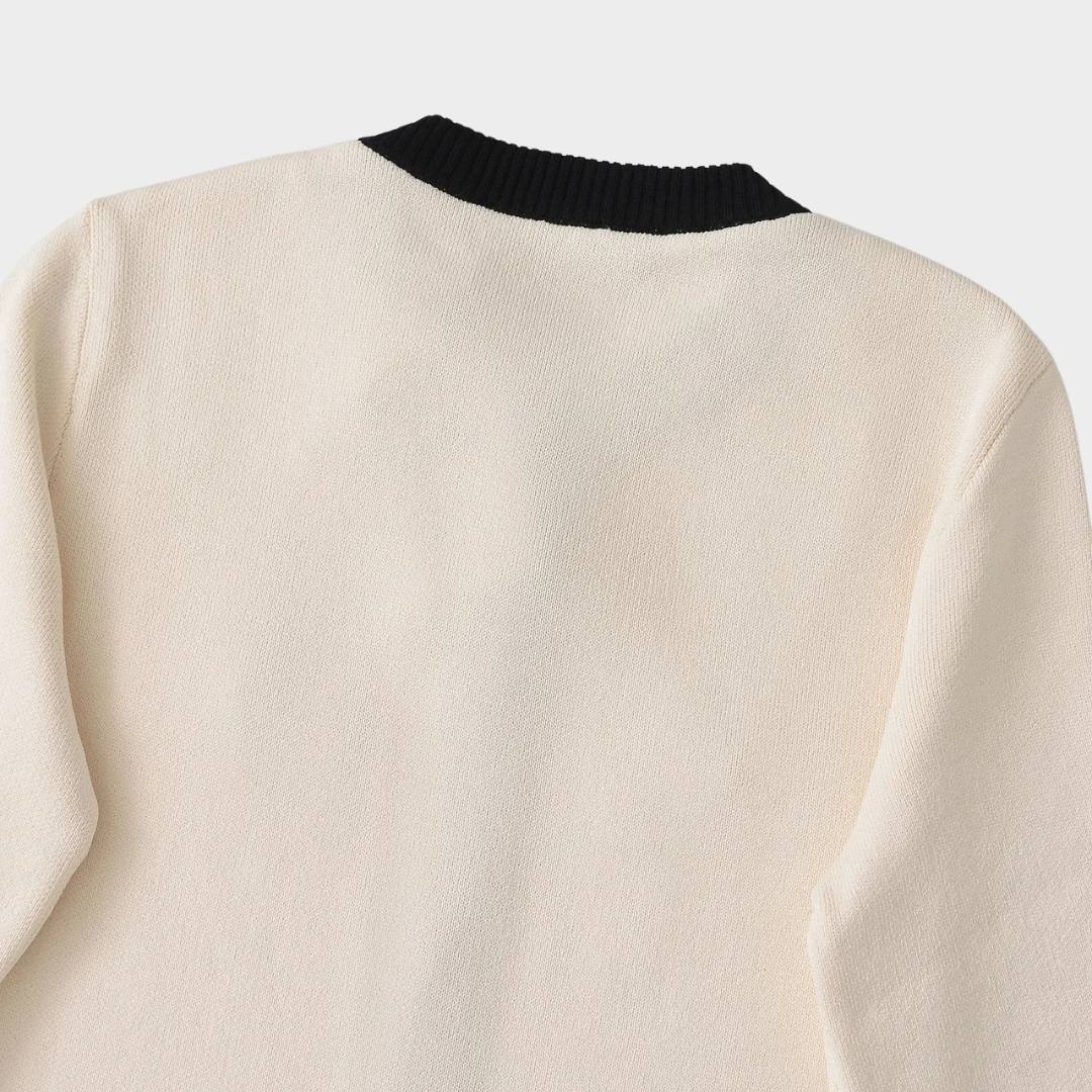 Elegant kort kofta med kontrastkant och guldfärgade knappar