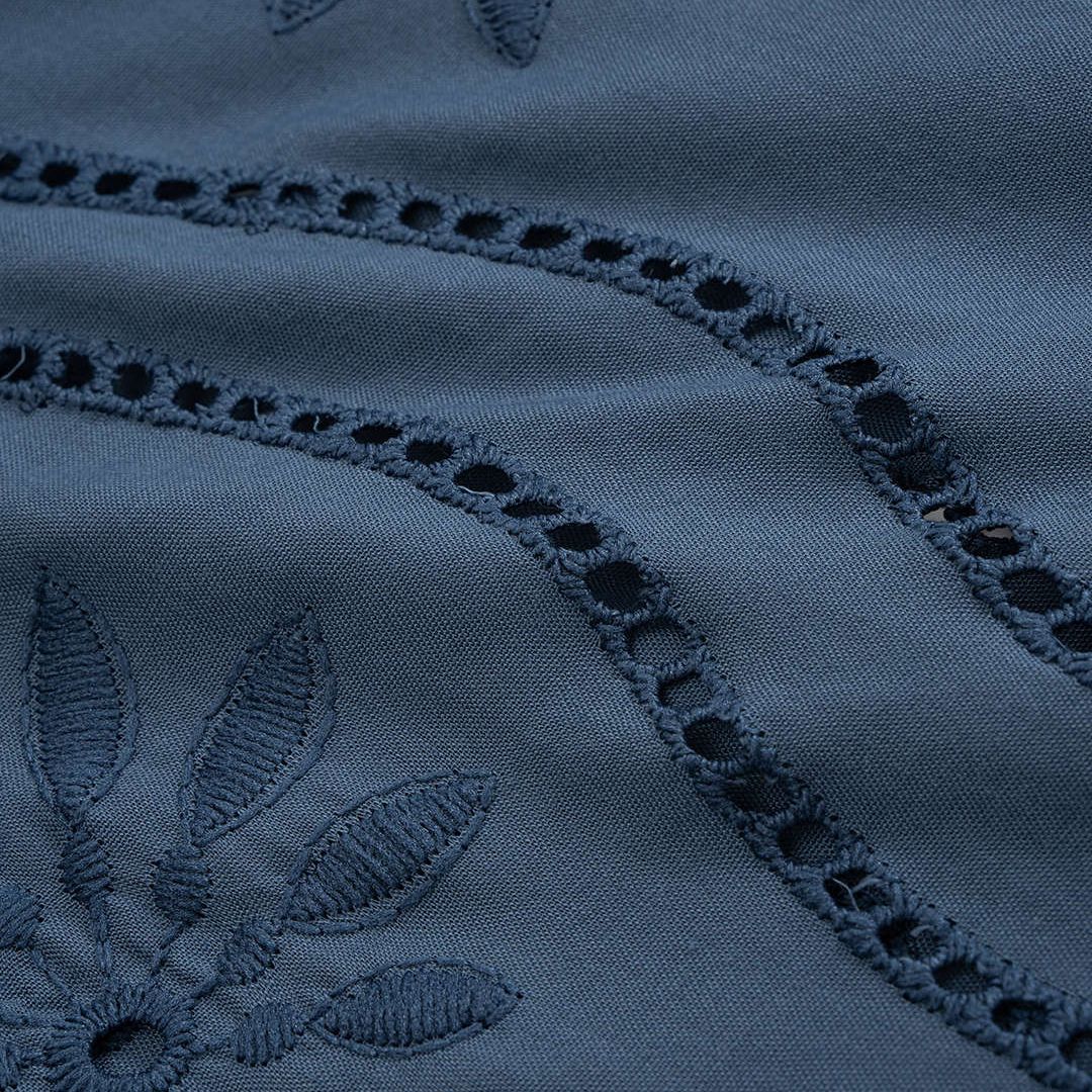 Blå blus med broderade blommor och transparent struktur