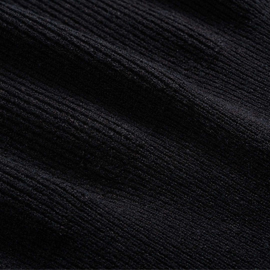 Svart figursydd stickad kofta i ribbat material med guldfärgade knappar och rund halsringning för dam