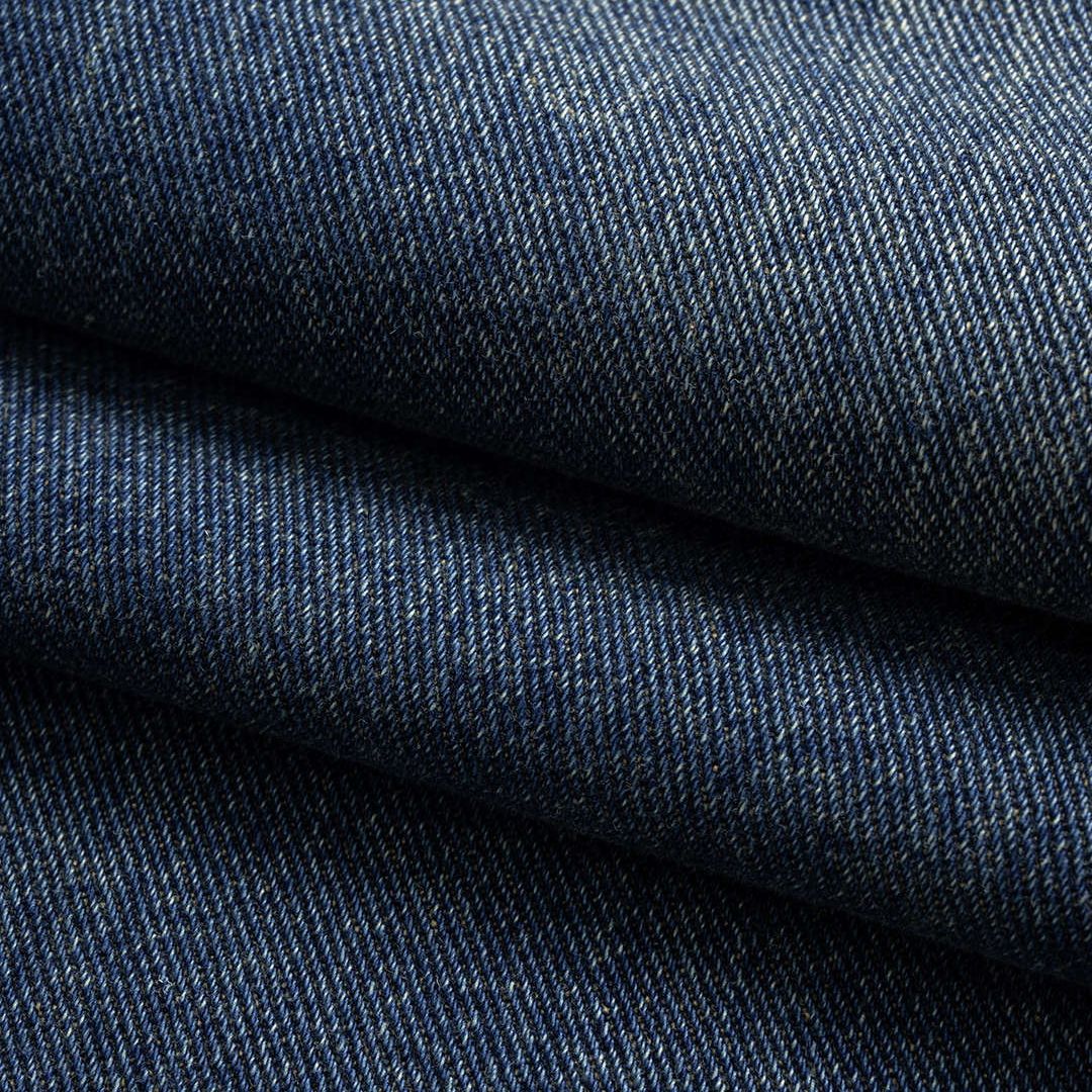 Mörkblå denimbyxa med markerad midja, kjol-liknande överdel och utställda ben