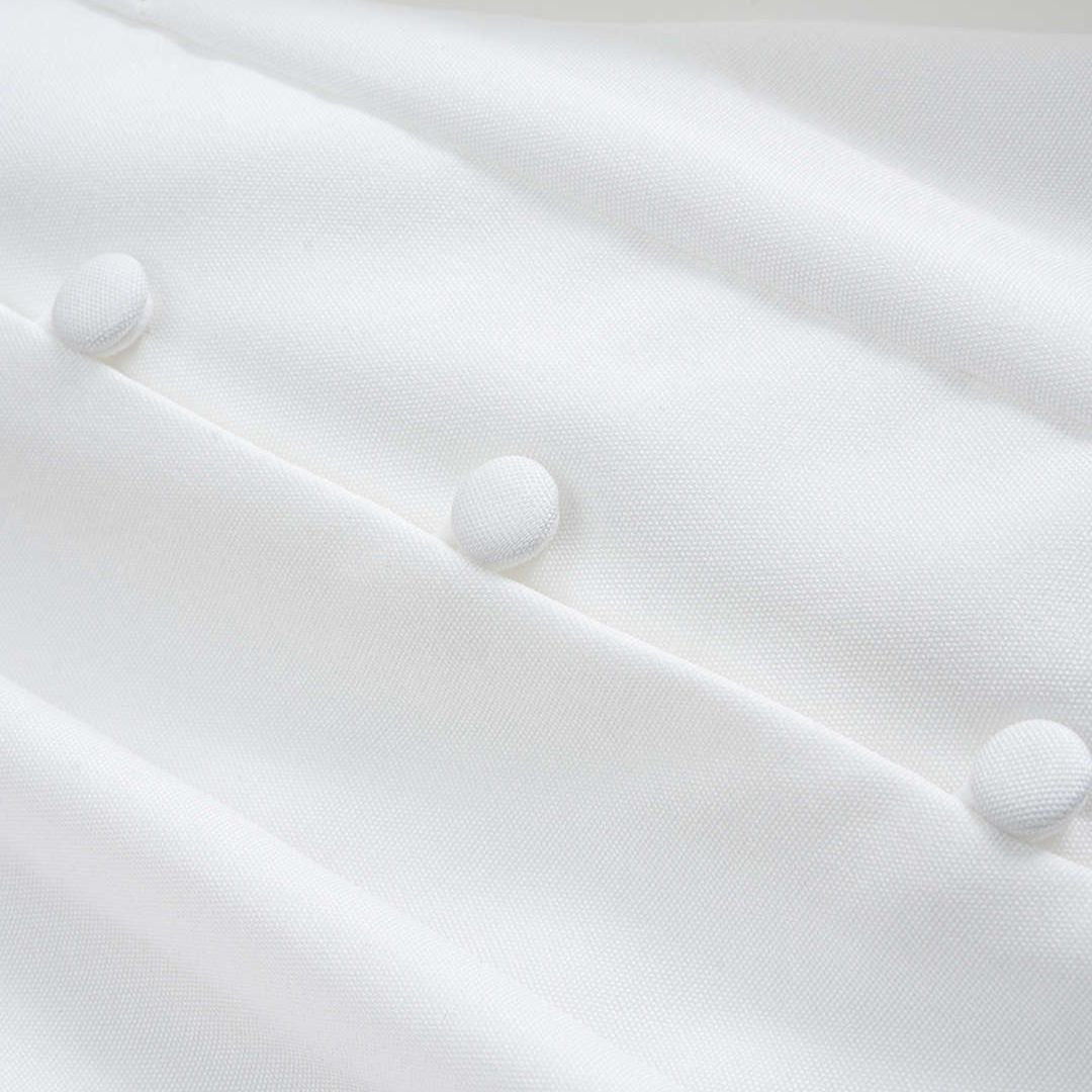 Vit blus med ståkrage täckta knappar och vida puffärmar