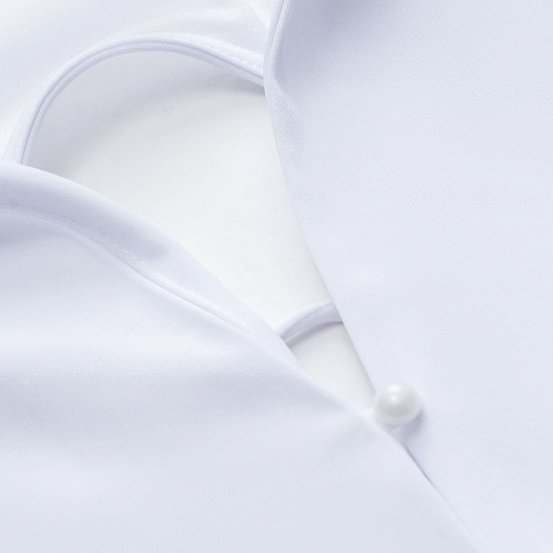 Vit långärmad topp med snörning i ryggen och pärlknappar framtill