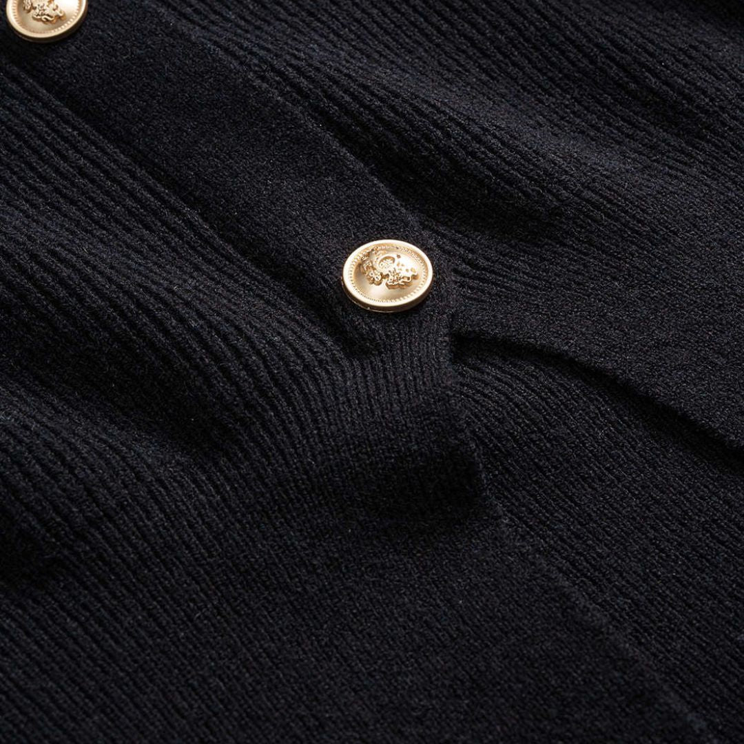 Svart figursydd stickad kofta i ribbat material med guldfärgade knappar och rund halsringning för dam