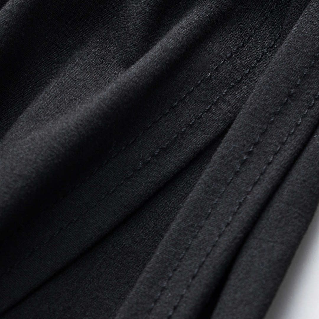 Svart ärmlös långklänning i jersey med figurnära silhuett och kontrasterande sidenrosetter i midjan