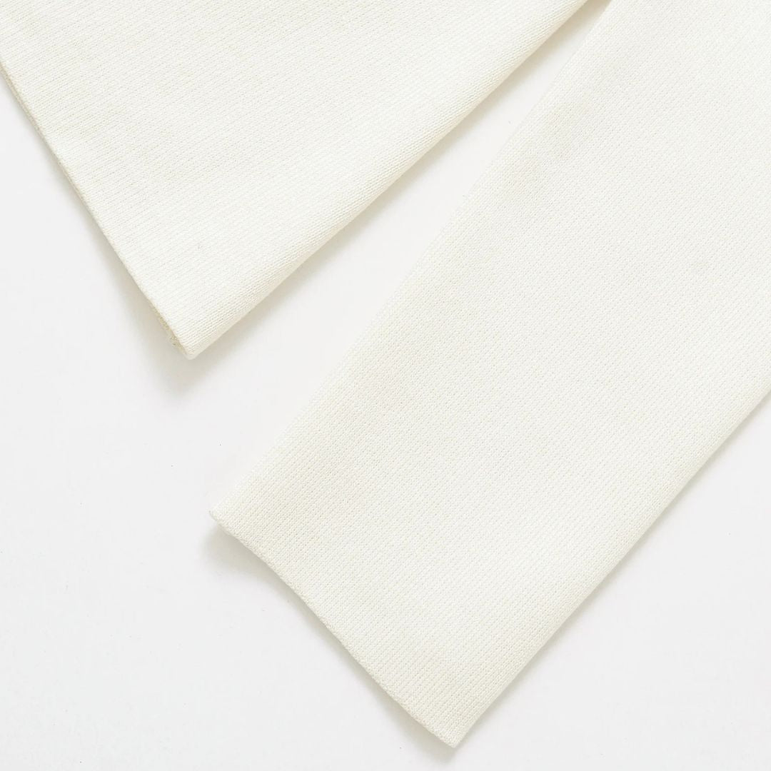 Pastellfärgad stickad kofta med V-ringning och guldfärgad knapp