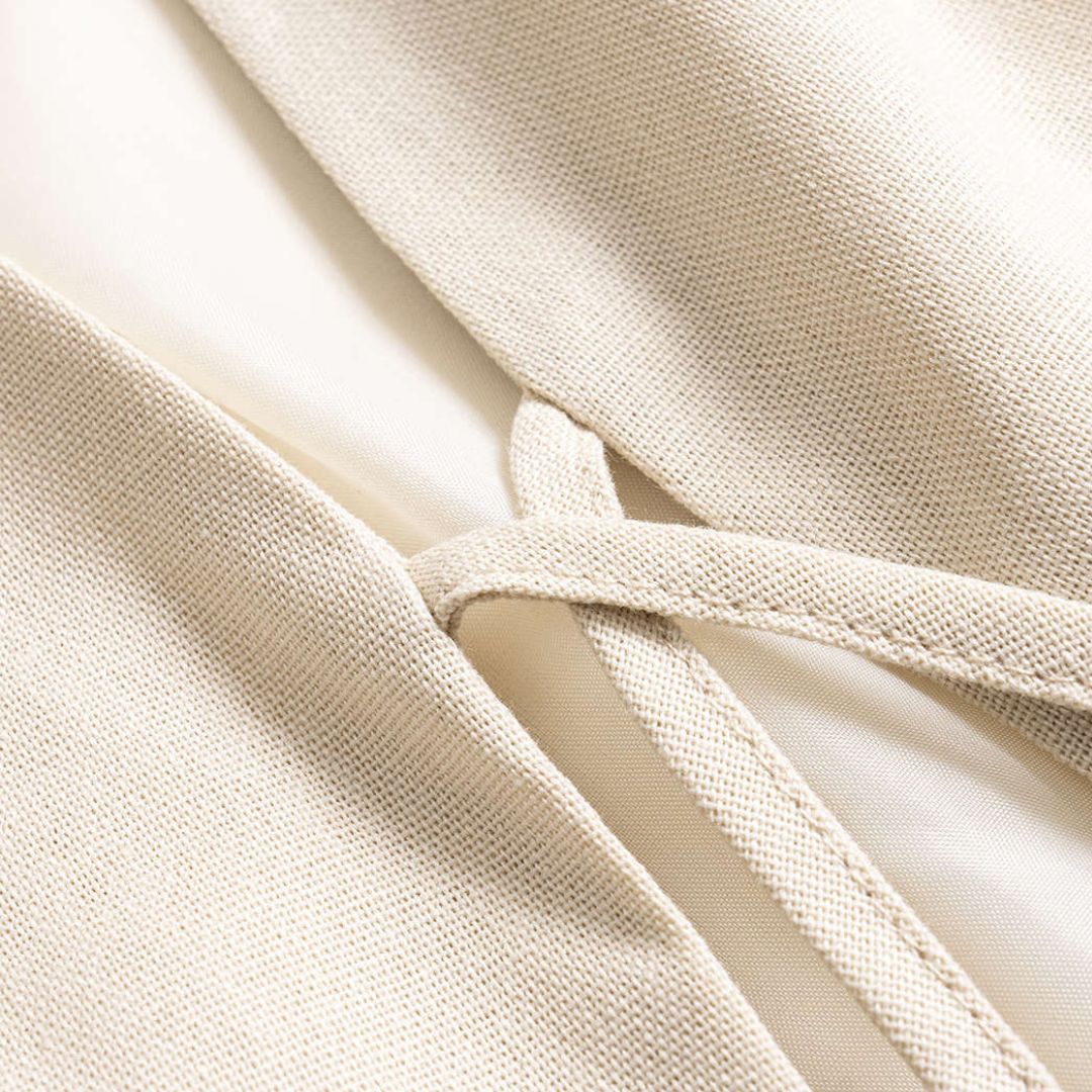 Beige ärmlös väst i vävd struktur med dekorativa snören och pärldetaljer