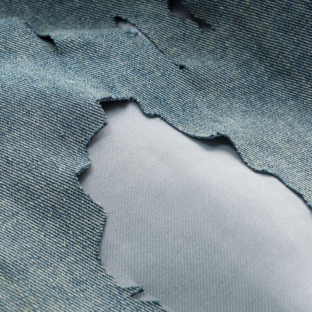 Höga ljusblå jeans med kraftiga slitningar, transparenta infällningar och bred rak passform i strukturerad denim