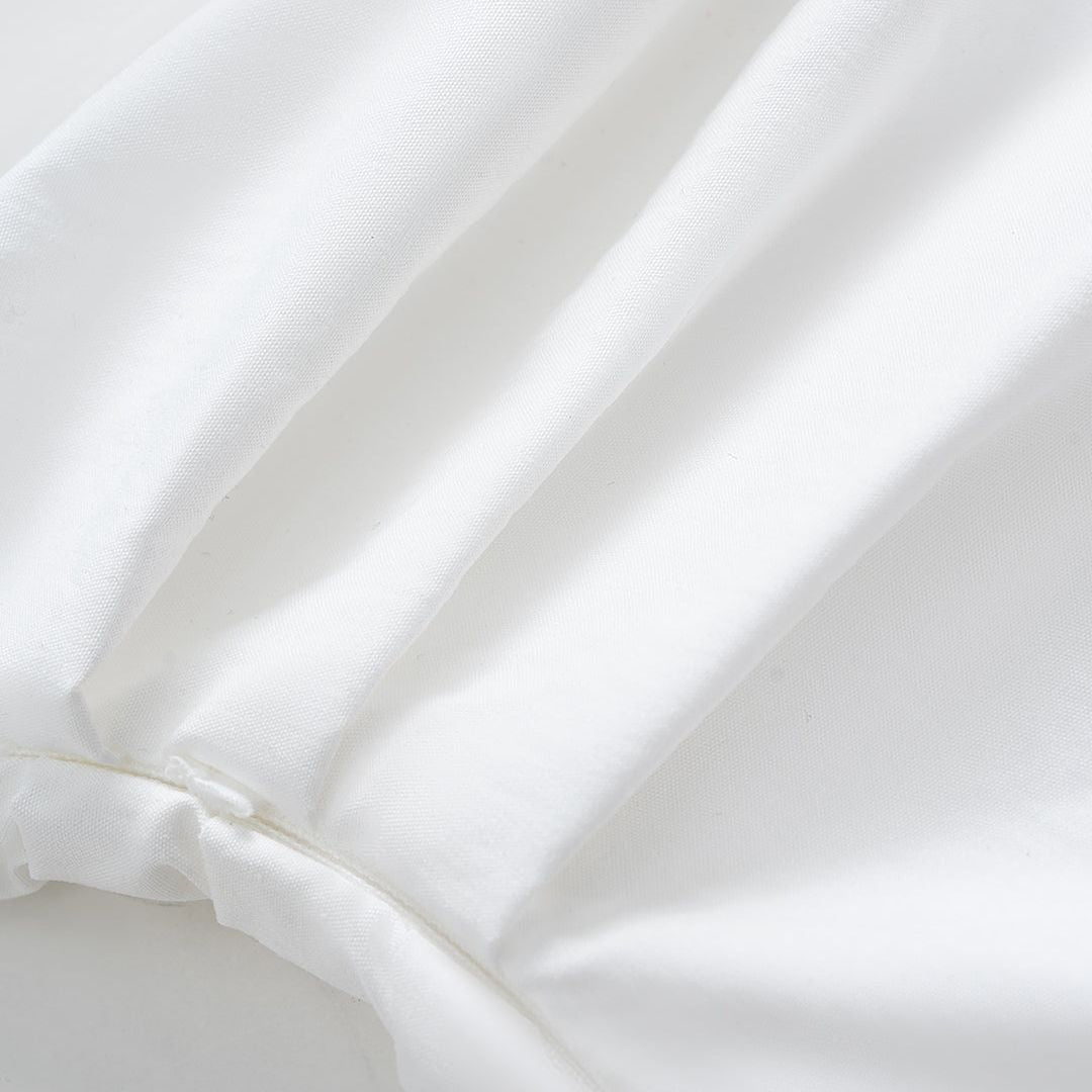 Asymmetrisk topp med bar axel och markerad midja stilren design med skulptural silhuett